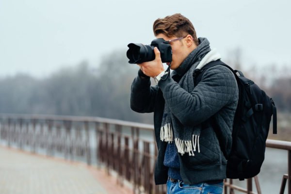 young-stylish-photographer-holds-professional-camera-taking-photos (1)